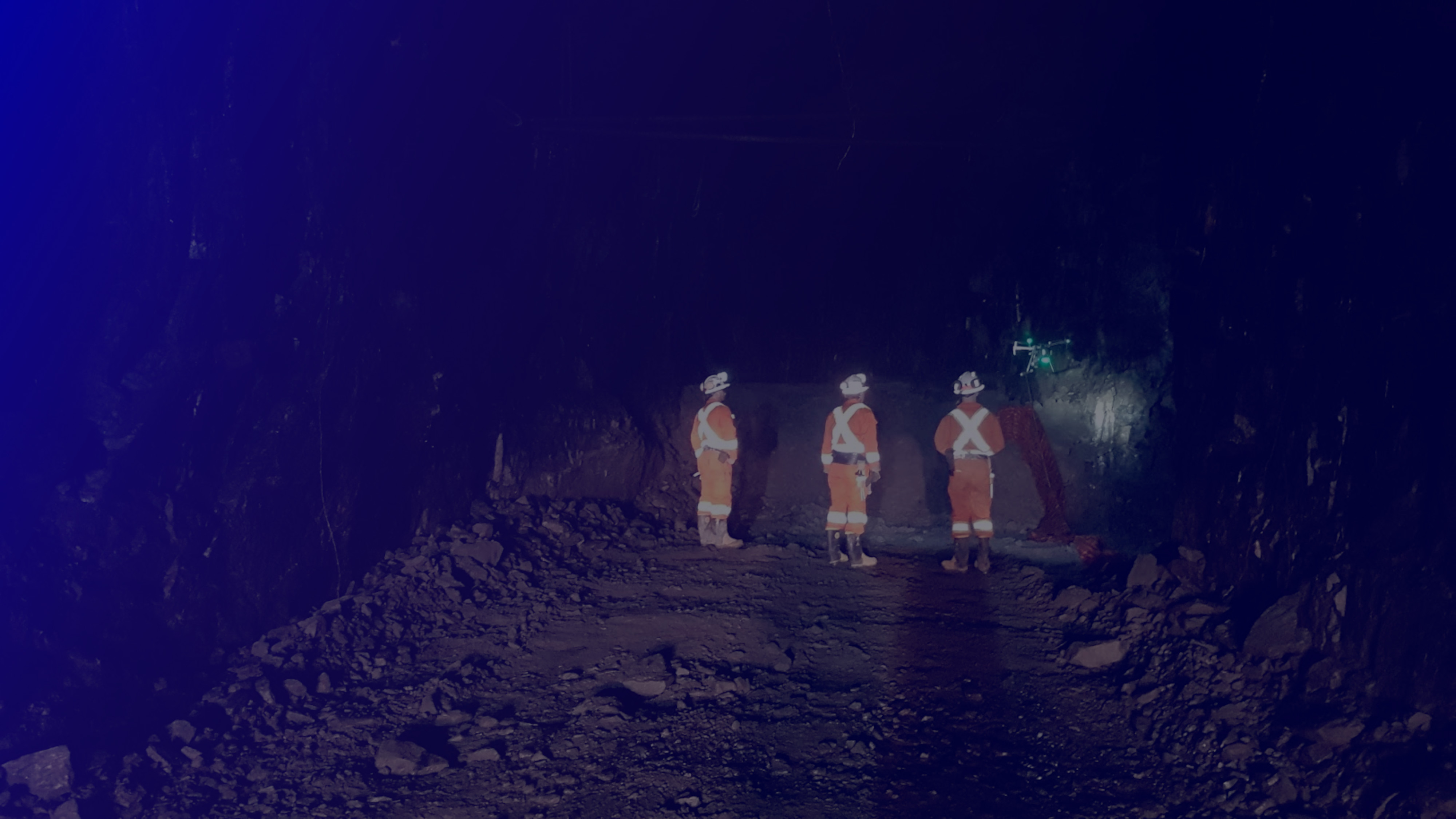 Mine crew watching a drone hover in the distance