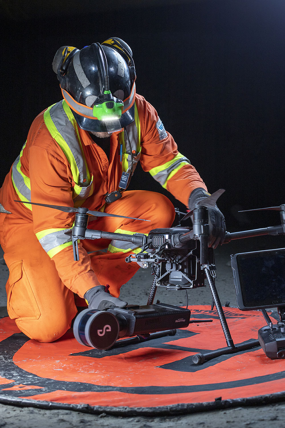 Technician preparing an Emesent Hovermap drone on a landing pad